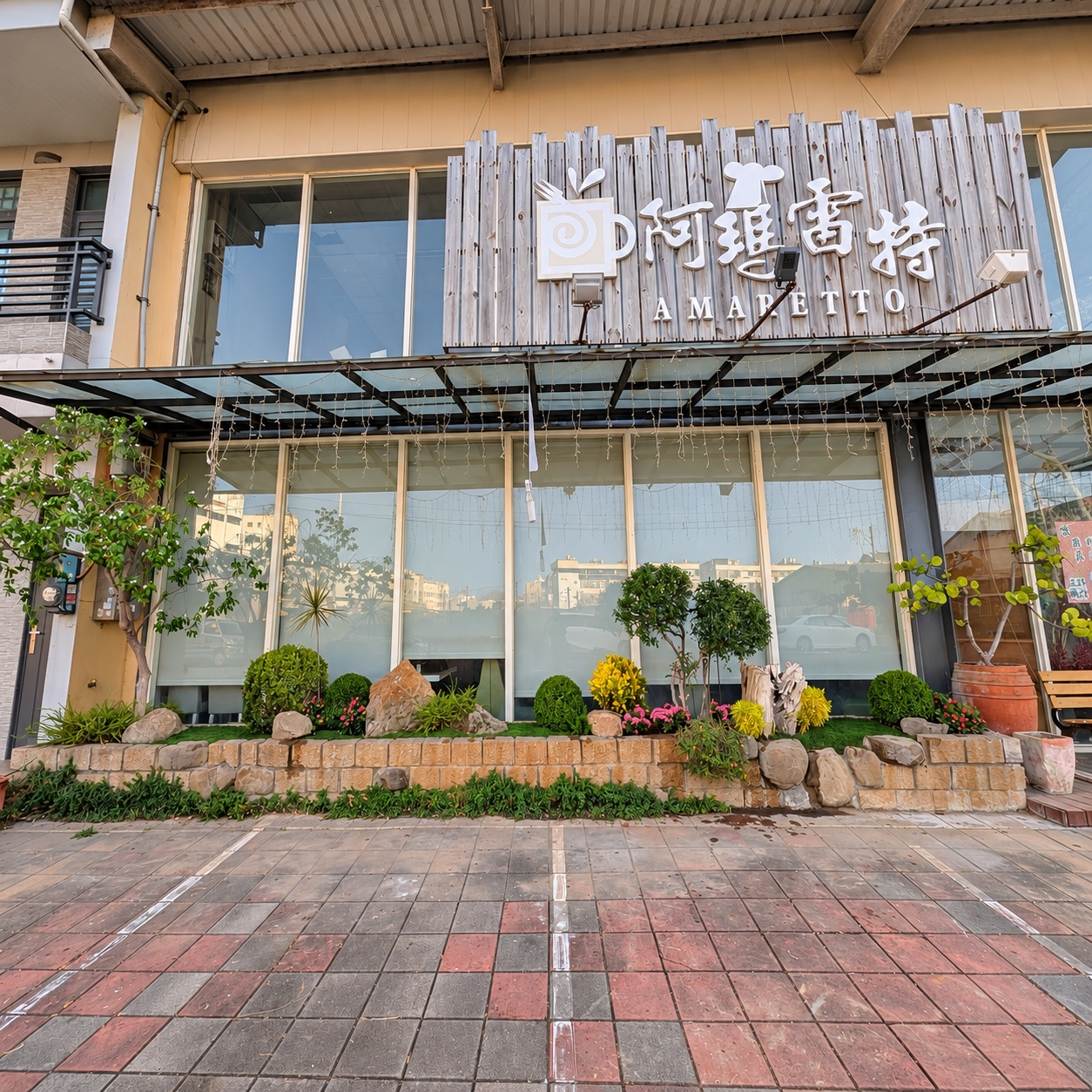 餐廳花台改造完成全景,長形花台沿著落地窗配置層次植栽與石景